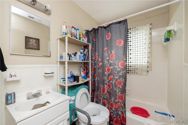 full bathroom with vanity, shower / tub combo, tile walls, and toilet