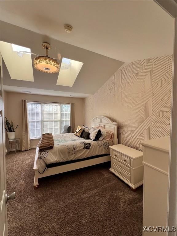 bedroom with a skylight and dark carpet