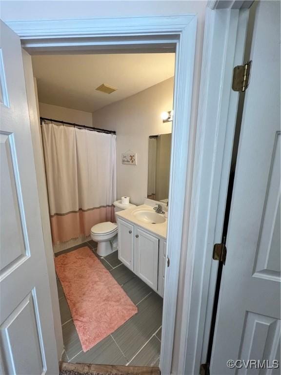 bathroom with a shower with curtain, tile patterned flooring, vanity, and toilet