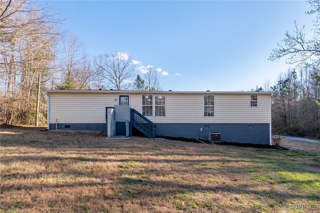 view of front facade with a front lawn and central air condition unit