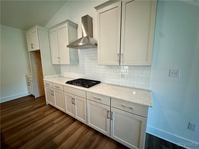 kitchen with white cabinetry, light stone counters, wall chimney range hood, and stainless steel gas cooktop