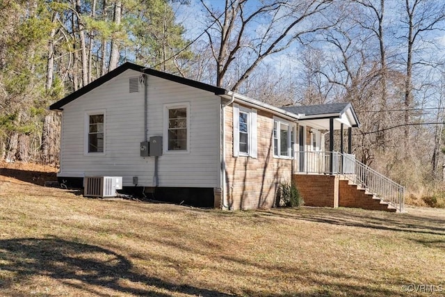 view of side of home with central air condition unit and a yard