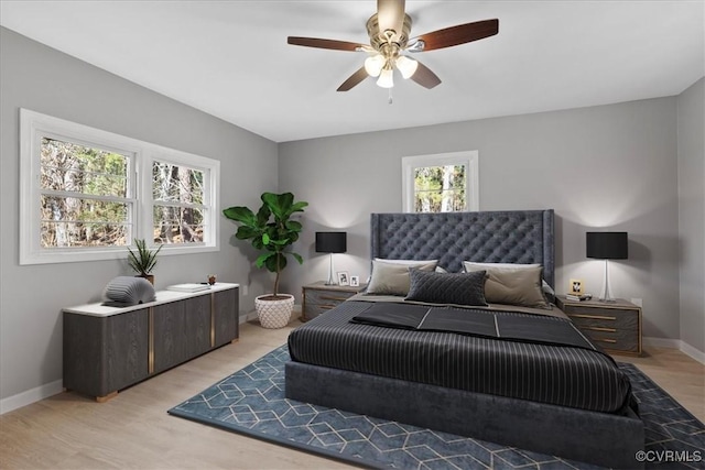 bedroom with multiple windows, ceiling fan, and light hardwood / wood-style flooring