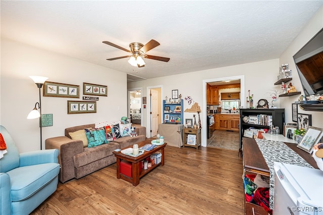 living room with ceiling fan, wood-type flooring, and a textured ceiling