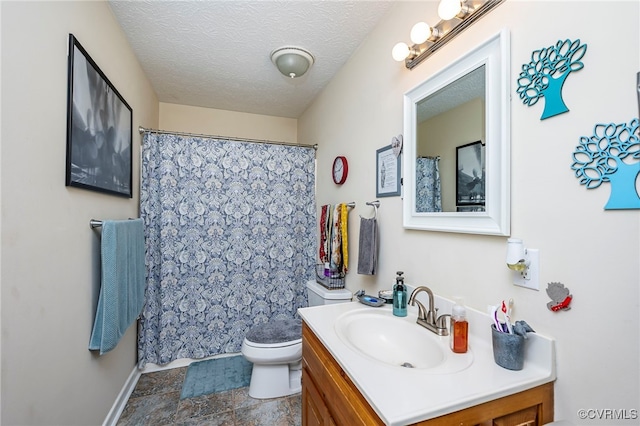 bathroom with vanity, a textured ceiling, and toilet