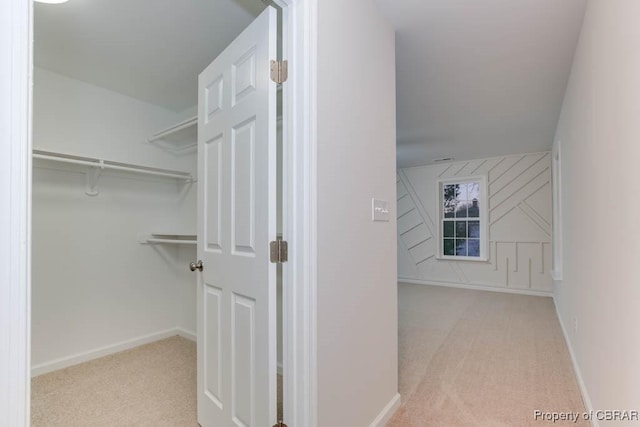 walk in closet featuring light colored carpet