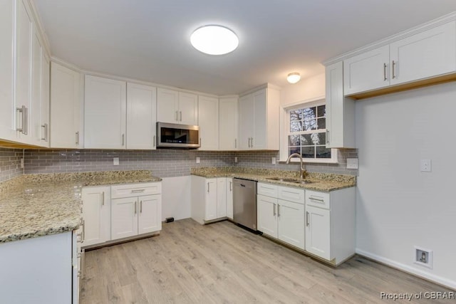 kitchen featuring white cabinets, sink, light stone countertops, and stainless steel appliances