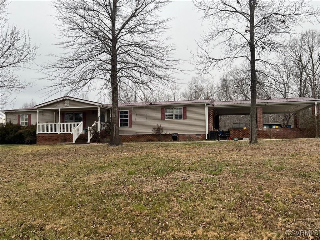 view of front facade featuring a porch, an attached carport, and a front lawn