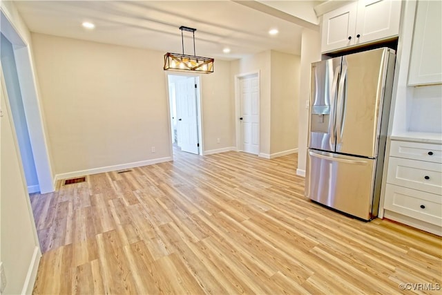 kitchen with white cabinetry, light hardwood / wood-style flooring, hanging light fixtures, and stainless steel refrigerator with ice dispenser