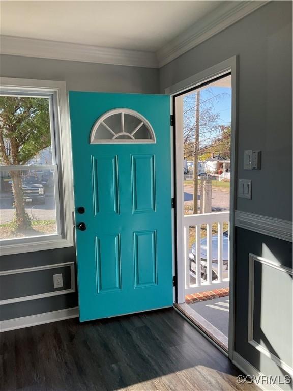 entryway with crown molding and dark wood-type flooring