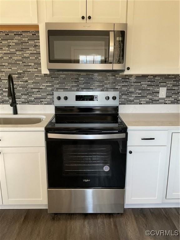 kitchen featuring white cabinets, sink, backsplash, and appliances with stainless steel finishes