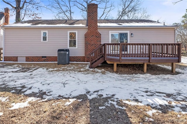 snow covered property with a deck and cooling unit