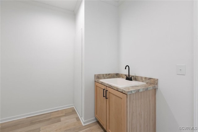 bathroom with hardwood / wood-style floors, vanity, and ornamental molding