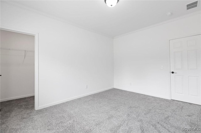 unfurnished bedroom featuring a spacious closet, a closet, carpet floors, and ornamental molding