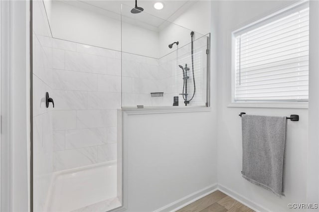 bathroom featuring a tile shower and wood-type flooring