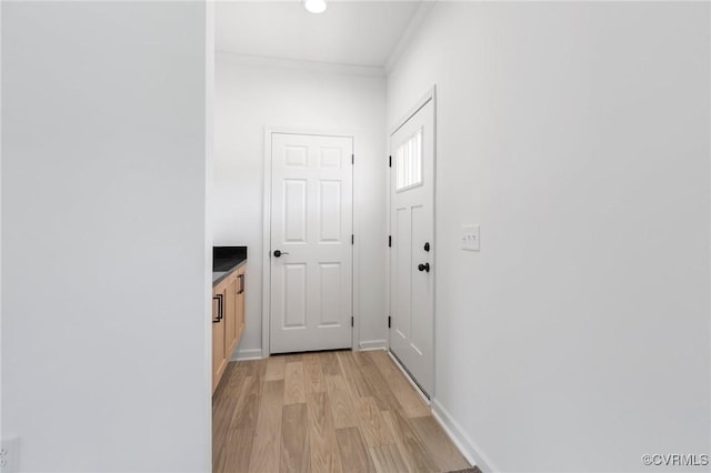 hall featuring light hardwood / wood-style flooring and ornamental molding