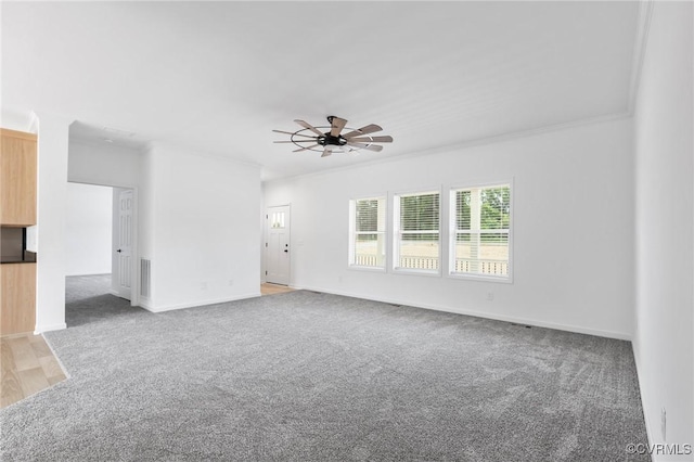 carpeted empty room with ceiling fan and ornamental molding