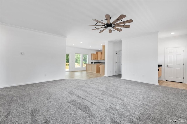 unfurnished living room with light colored carpet, ceiling fan, and crown molding