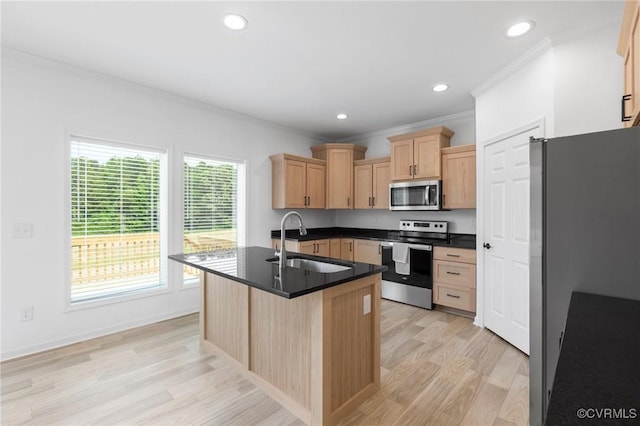 kitchen with light brown cabinetry, stainless steel appliances, sink, a center island with sink, and light hardwood / wood-style flooring