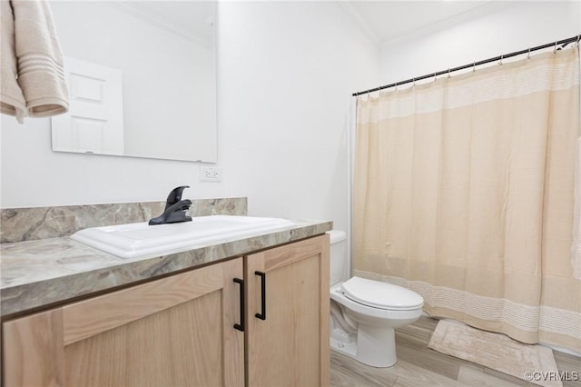 bathroom featuring a shower with curtain, hardwood / wood-style floors, toilet, vanity, and ornamental molding