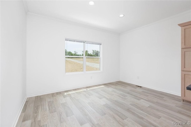 spare room featuring crown molding and light wood-type flooring