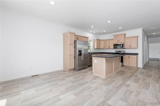 kitchen with a center island, crown molding, stainless steel appliances, and light brown cabinetry