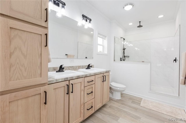 bathroom featuring a tile shower, hardwood / wood-style flooring, ornamental molding, and toilet