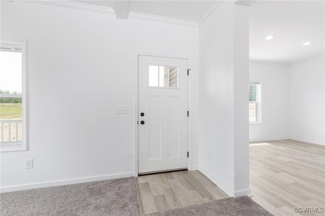 foyer entrance with light wood-type flooring and ornamental molding