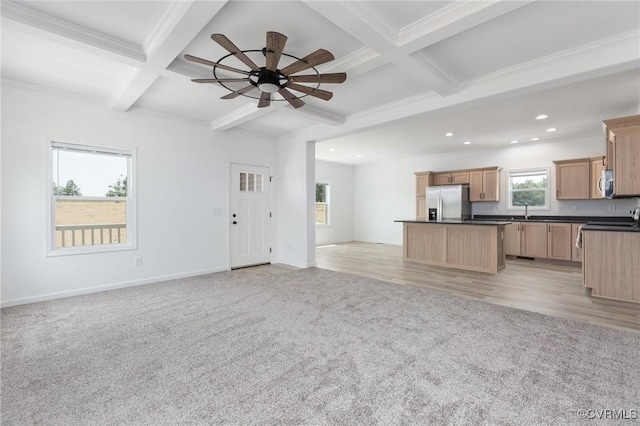 unfurnished living room with beam ceiling, ceiling fan, light colored carpet, and coffered ceiling