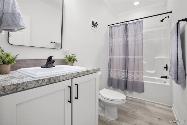 full bathroom with ornamental molding, vanity, shower / bath combo with shower curtain, hardwood / wood-style flooring, and toilet