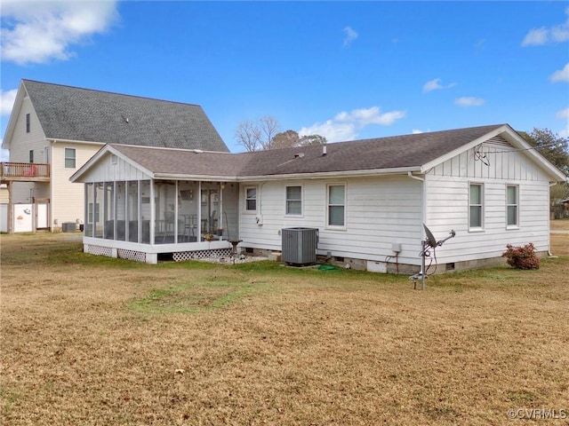 rear view of house featuring cooling unit, a yard, a sunroom, a shingled roof, and crawl space