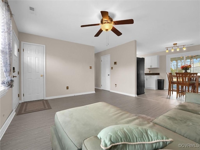 living room with ceiling fan and dark hardwood / wood-style floors