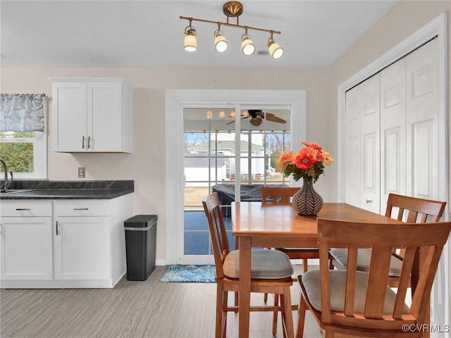 dining room with ceiling fan, light hardwood / wood-style floors, and sink