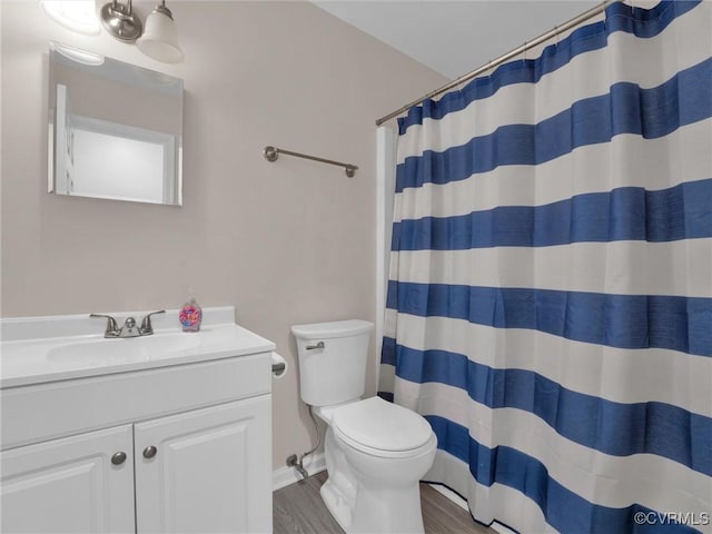 bathroom featuring wood-type flooring, toilet, walk in shower, and vanity