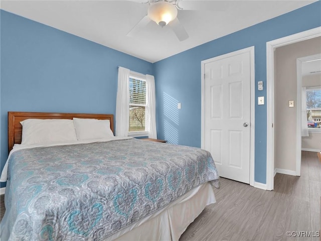 bedroom featuring wood finished floors, baseboards, and ceiling fan