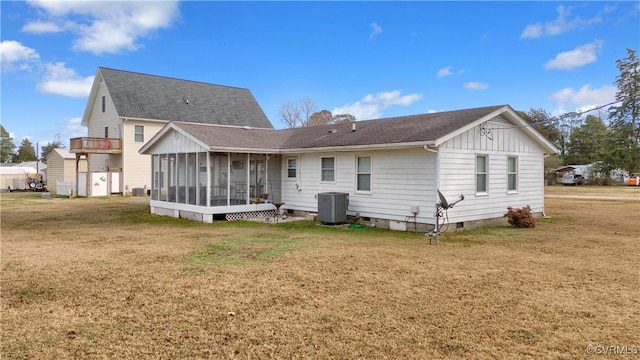 rear view of house featuring a yard, central AC unit, a sunroom, and crawl space