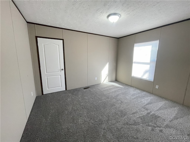 spare room featuring carpet and a textured ceiling