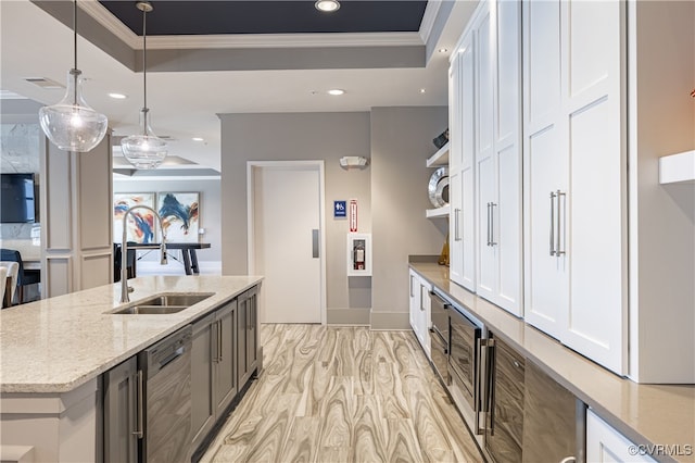 kitchen featuring white cabinets, a raised ceiling, sink, and hanging light fixtures