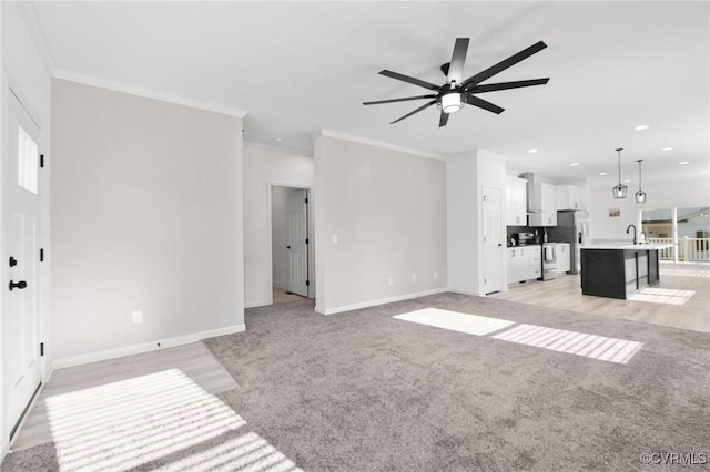 carpeted living room with ceiling fan, sink, and crown molding