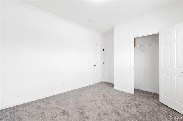 unfurnished bedroom featuring carpet flooring, crown molding, and a closet