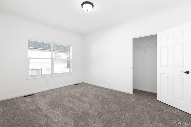 unfurnished bedroom with dark colored carpet, ornamental molding, and a closet