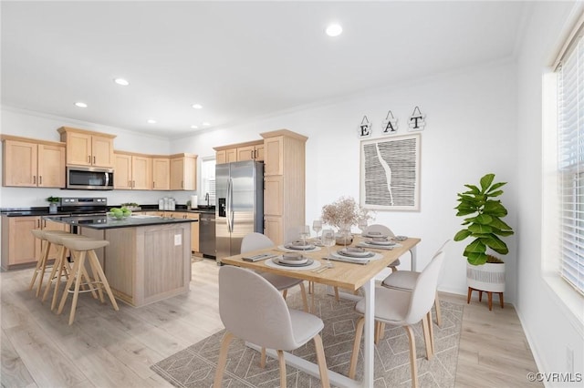 kitchen featuring crown molding, plenty of natural light, light hardwood / wood-style floors, and appliances with stainless steel finishes