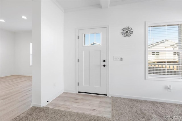 carpeted foyer entrance featuring ornamental molding