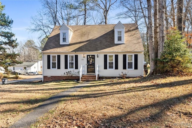 cape cod home with a front lawn