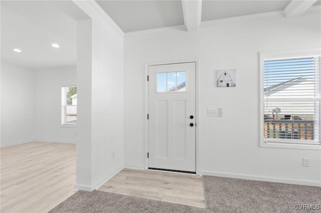 foyer featuring crown molding, beamed ceiling, and light wood-type flooring