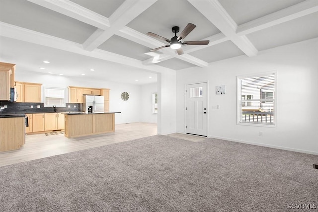 unfurnished living room featuring beamed ceiling, light carpet, and coffered ceiling