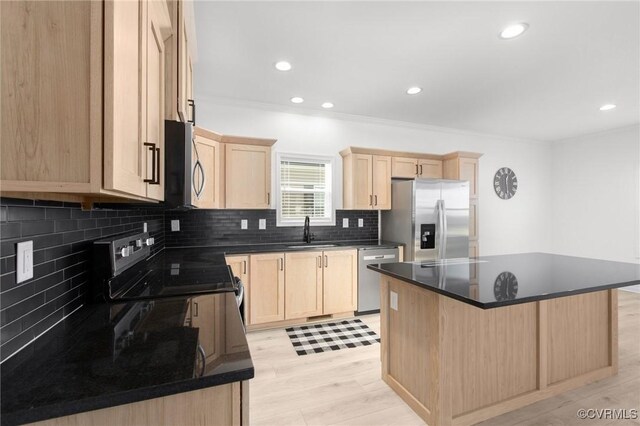 kitchen featuring light brown cabinets, stainless steel appliances, a kitchen island, and sink