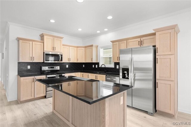 kitchen with light wood-type flooring, crown molding, and appliances with stainless steel finishes