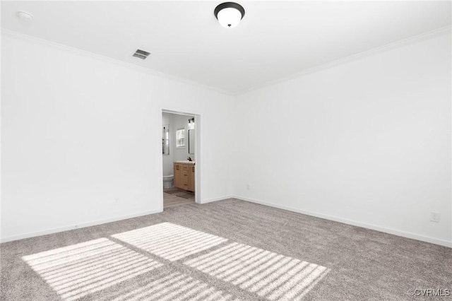 spare room with ornamental molding and light carpet