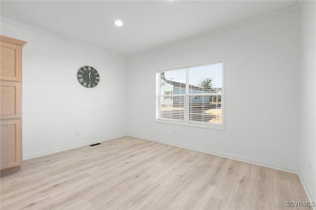 spare room with ornamental molding and light hardwood / wood-style flooring